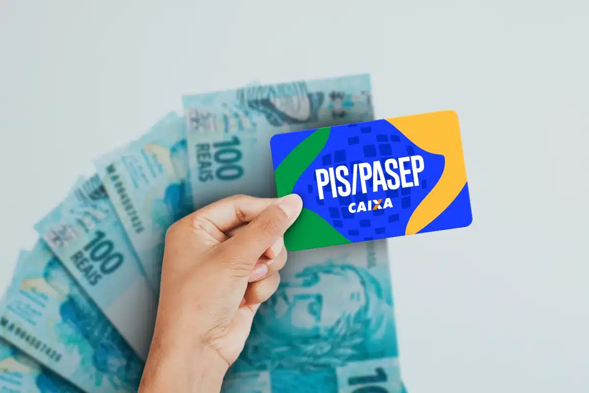 Cartão PIS/PASEP Caixa sobre uma pilha de notas de 100 reais, representando a consulta de saldo disponível no fundo