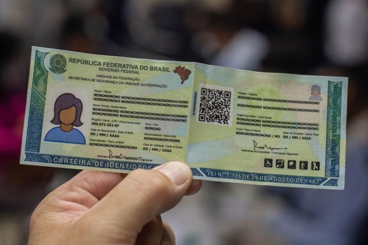 Mão segurando nova Carteira de Identidade Nacional com QR Code e dados unificados