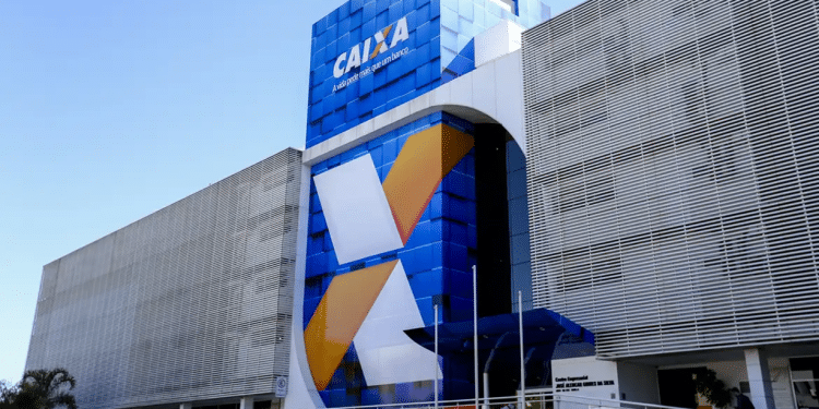 Fachada azul moderna da agência CAIXA com logo grande e estrutura metálica em dia ensolarado.