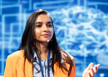 Mulher palestrando sobre inteligência artificial e profissões do futuro em um evento de negócios.