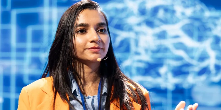 Mulher palestrando sobre inteligência artificial e profissões do futuro em um evento de negócios.