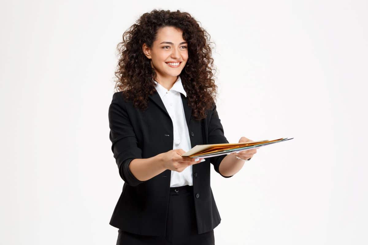 Jovem profissional sorridente oferecendo documentos, simbolizando oportunidades de carreira com altos salários