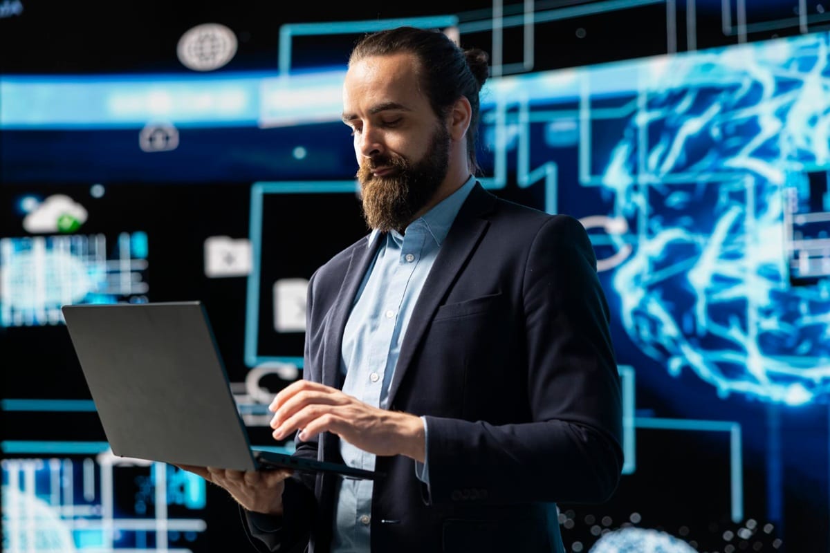 Especialista em cibersegurança analisando dados em laptop com interfaces digitais holográficas ao fundo