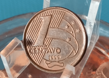 Moeda rara de 1 centavo em primeiro plano, exibindo a data de cunhagem, que pode valer até R$ 1.000 para colecionadores devido a um detalhe de erro de fabricação ou cunhagem reversa.