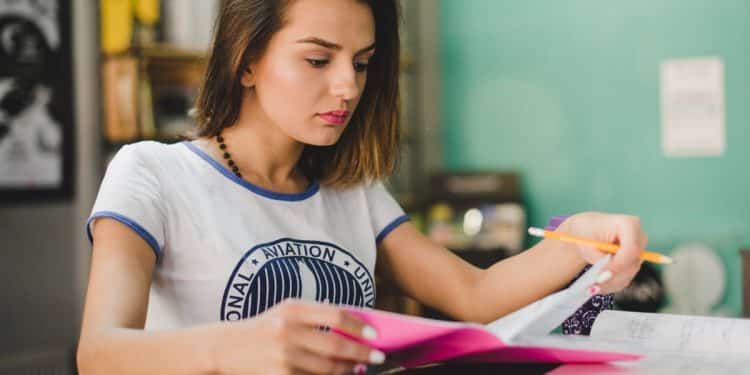 Candidata organizando materiais de estudo com marca-textos para preparação da redação