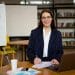 Profissional de RH estudando com materiais e laptop em ambiente corporativo