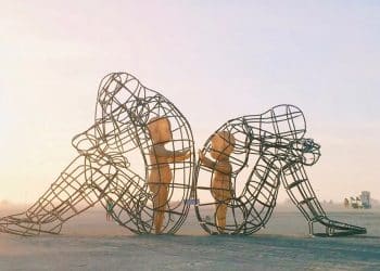 Escultura representando a conexão com a criança interior, com figuras humanas em estruturas metálicas, simbolizando o vínculo emocional profundo entre o passado e o presente.