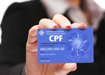Pessoa segurando cartão de CPF do Ministério da Fazenda mostrando documento de identificação