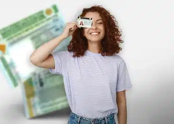 Mulher sorridente segurando a CNH perto do rosto com fundo da carteira de motorista desfocado.