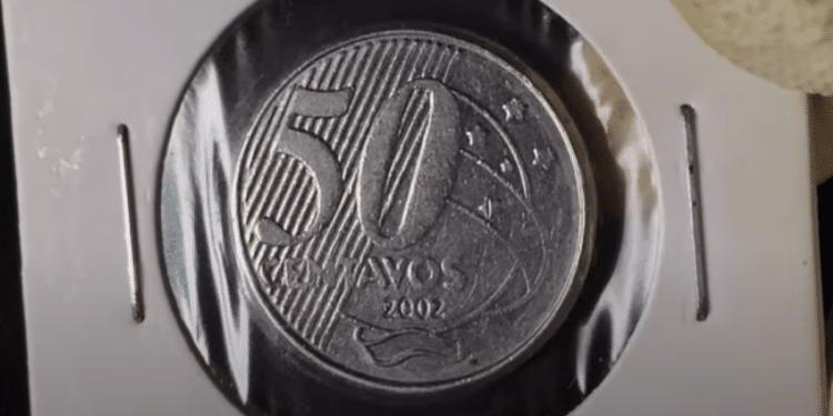 Moeda brasileira de 50 Centavos, ano 2002, guardada em proteção para colecionador, indicando seu potencial de valorização acima de R$ 100 na numismática.