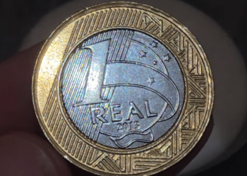 Close-up da moeda de 1 Real com o ano 2013, o exemplar comum que, com um defeito de cunhagem, pode valer uma fortuna entre colecionadores de moedas raras.