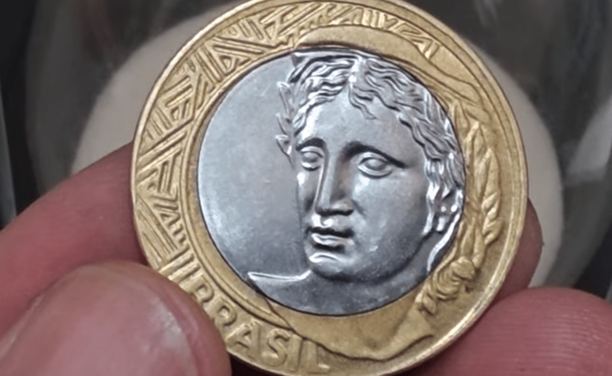 Close-up do anverso da moeda de 1 Real, que mostra a efígie da República, representando o exemplar de 2013 que com erro de núcleo descentralizado vale até R$ 250.