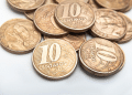 Close-up de moedas de 10 centavos com anos variados (2016, 2008), ilustrando as raras que podem valer mais de R$ 150 devido a defeitos de cunhagem.