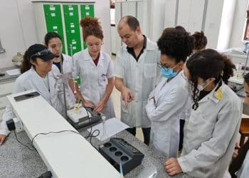 Professor e estudantes do Coltec em aula prática de laboratório com equipamentos científicos