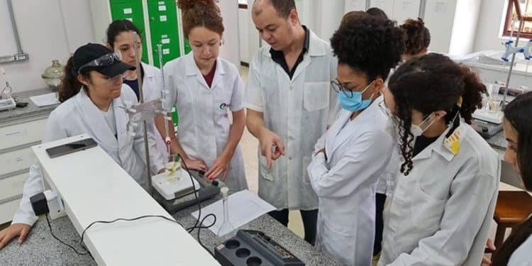 Professor e estudantes do Coltec em aula prática de laboratório com equipamentos científicos