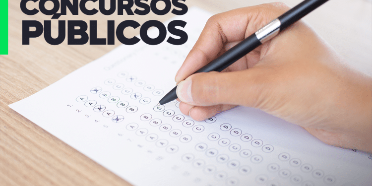 Mão preenchendo prova objetiva de múltipla escolha para concursos públicos com caneta preta.