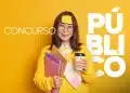 Jovem sorridente com suéter amarelo e óculos, segurando cadernos e café, preparada para concurso público