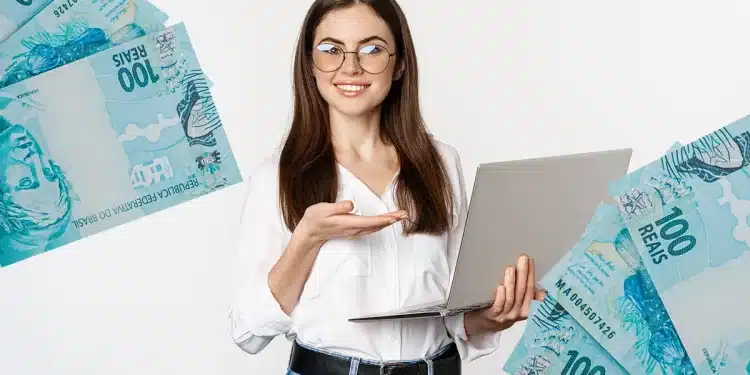Mulher jovem e sorridente, de óculos, aponta para um notebook enquanto segura a tela.