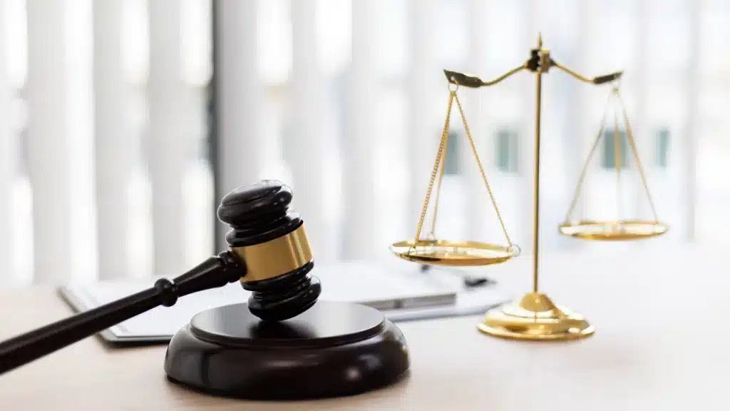 Martelo de juiz e balança dourada sobre mesa, representando a justiça e o equilíbrio nas decisões jurídicas.