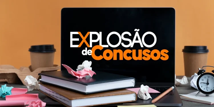 Mesa com livros, laptop mostrando Explosão de Concursos e materiais de estudo espalhados.