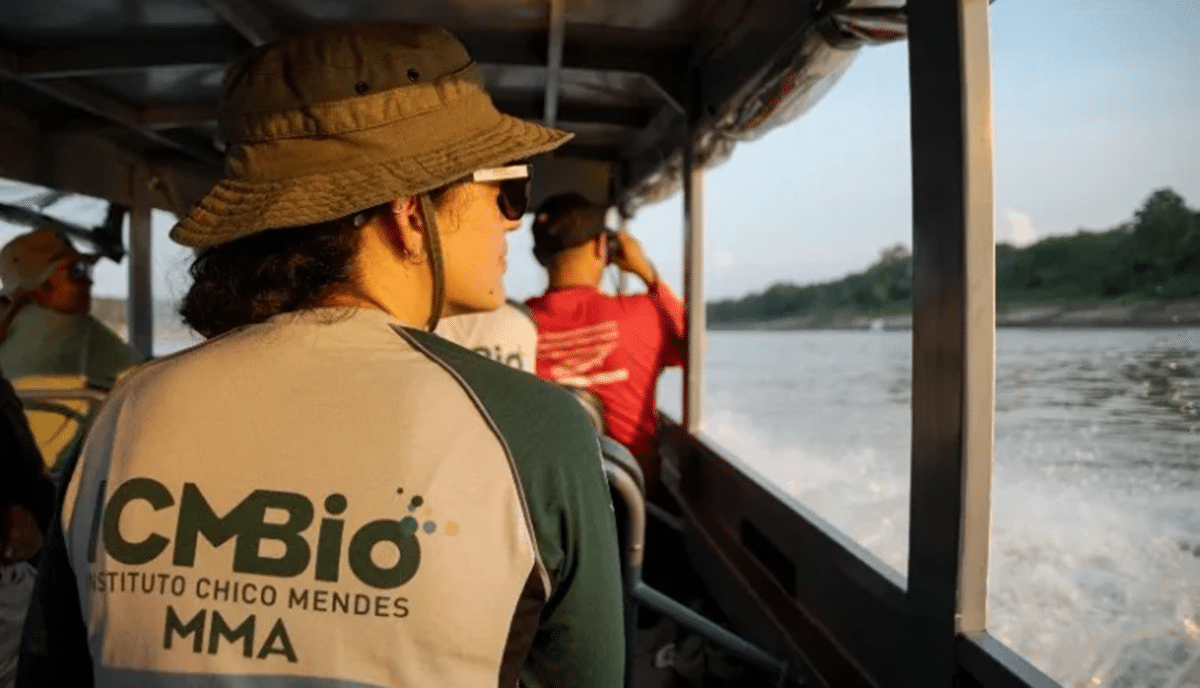 Profissional do ICMBio em atividade de campo navegando em rio amazônico