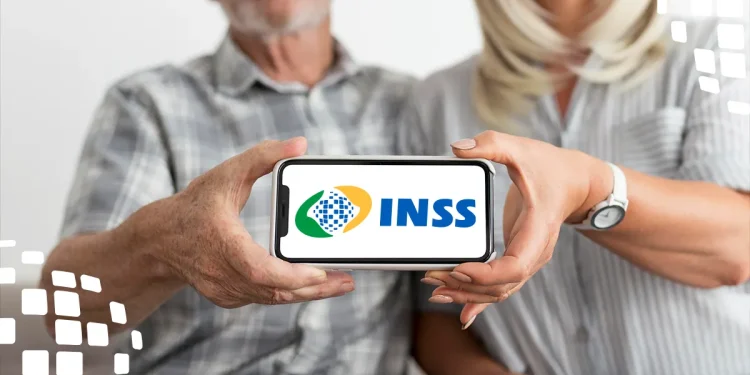Casal idoso segurando celular com logo do INSS visível na tela.