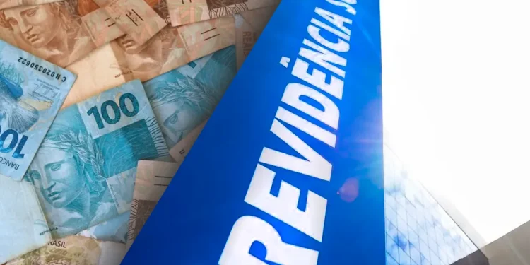 Dinheiro em notas de real com placa azul da Previdência Social ao lado de prédio moderno.