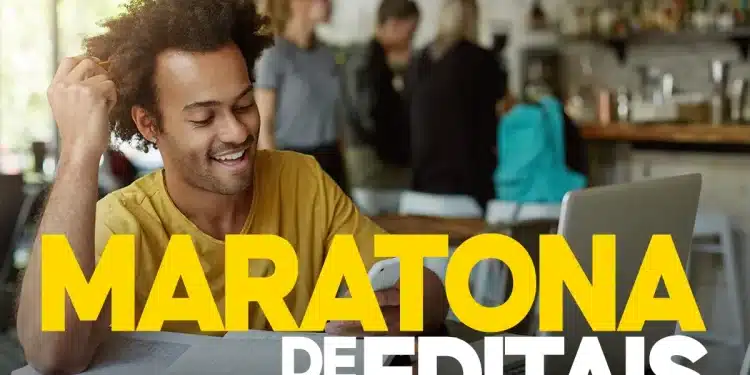 Candidato sorridente de camiseta amarela estudando em laptop durante maratona de inscrições para múltiplos concursos