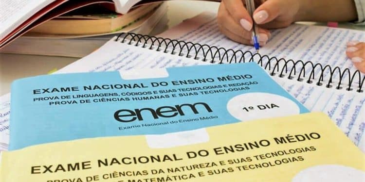 Cadernos de prova do Enem sobre mesa com materiais de estudo representando revisão eficiente nos dias finais antes do exame