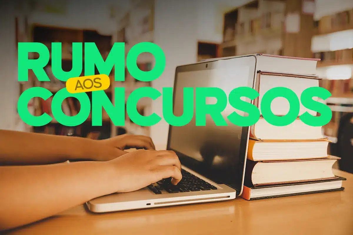 Mãos digitando em laptop ao lado de pilha de livros com texto Rumo aos Concursos representando preparação final