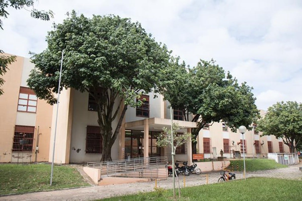 Fachada externa do prédio do Colégio Técnico da UFMG com área verde no campus