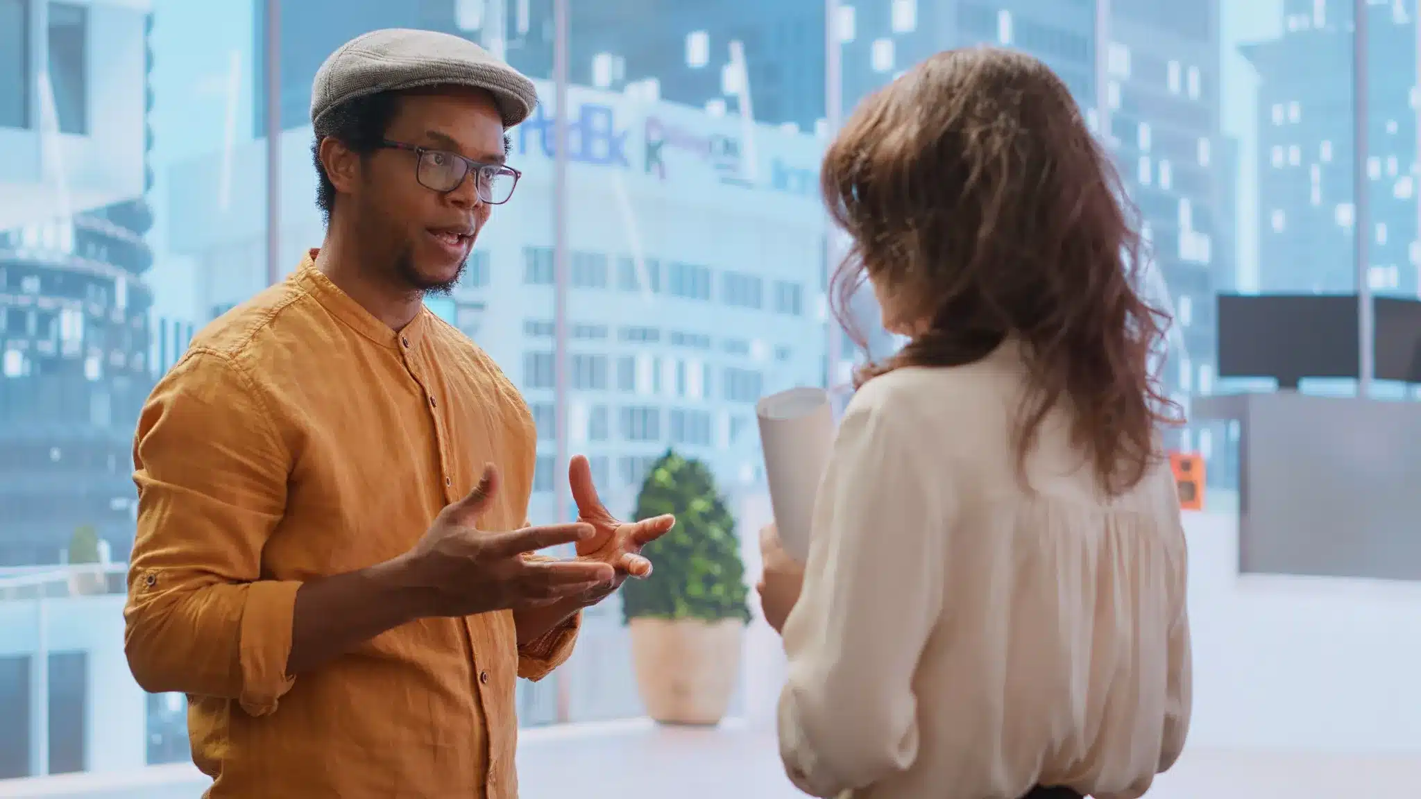 Duas pessoas inteligentes conversando sobre ideias e decisões no ambiente de trabalho moderno.