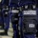 Guarda Municipal alinhada em formação vestindo uniforme azul com bolsa preta e identificação.