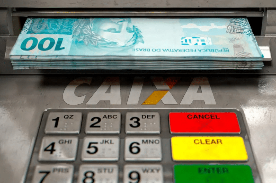 Caixa eletrônico da Caixa Econômica Federal liberando notas de R$ 100.