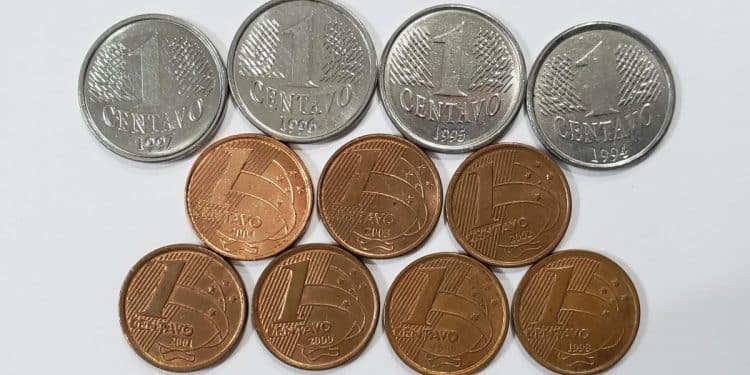 Coleção de moedas de 1 centavo de diversos anos, incluindo modelos antigos prateados e cobreados, sobre um fundo branco, ilustrando as raridades numismáticas.