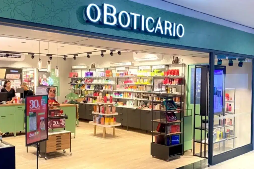 Loja O Boticário: um reflexo das Oportunidades de carreira no Grupo Fachada luminosa de uma loja O Boticário, com prateleiras repletas de produtos cosméticos em destaque, representando a grandiosidade e as oportunidades de trabalho na empresa.