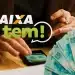 Aplicativo Caixa Tem aberto no celular com notas de 100 reais ao lado, relacionado ao pagamento de R$ 200.