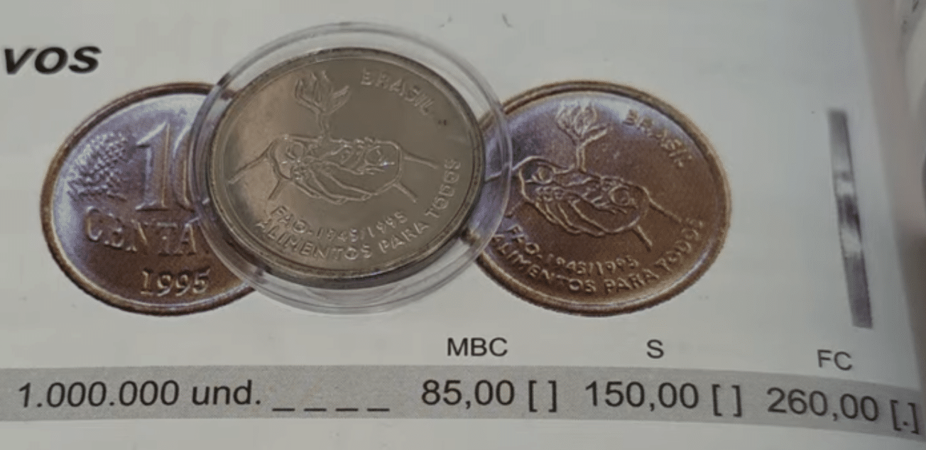 Moeda rara de 10 centavos do Real, série FAO 1995 (duas mãos oferecendo um fruto), em cápsula de proteção, sobre um catálogo numismático que indica a tiragem de 1 milhão de unidades e valores de R$ 85 a R$ 260 dependendo da conservação (MBC, Soberba, Flor de Cunho).