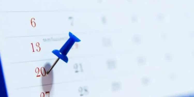 Um calendário com um alfinete azul marcando o número 20, sugerindo a data do feriado de Consciência Negra.