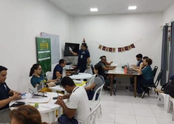 Equipe da Defensoria Pública atendendo múltiplos cidadãos simultaneamente durante mutirão gratuito de documentação