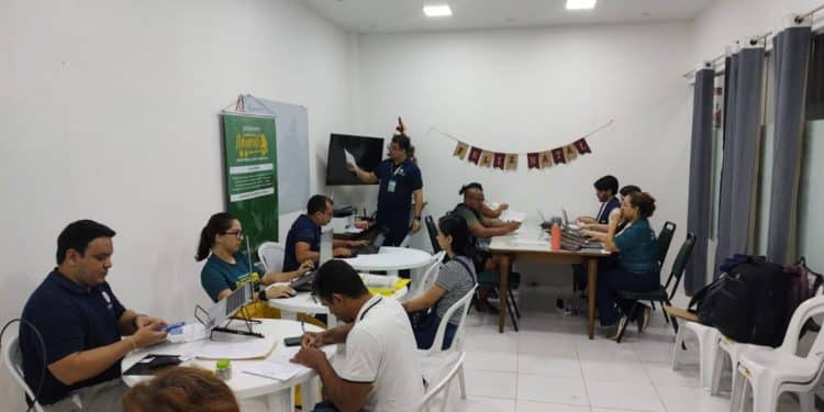 Equipe da Defensoria Pública atendendo múltiplos cidadãos simultaneamente durante mutirão gratuito de documentação