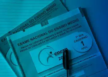 Cadernos de prova azul e rosa do Exame Nacional do Ensino Médio (ENEM) de 2025, com uma caneta preta sobre o caderno do primeiro dia.