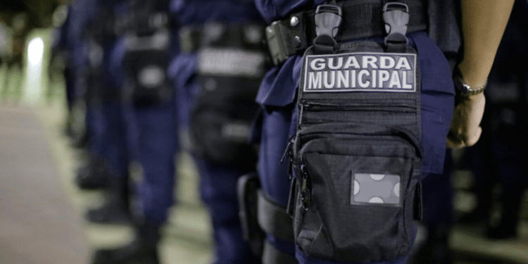 Guarda Municipal em uniforme azul alinhados durante formação noturna