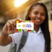 Jovem estudante sorrindo, mostrando o cartão colorido do programa Pé-de-Meia.
