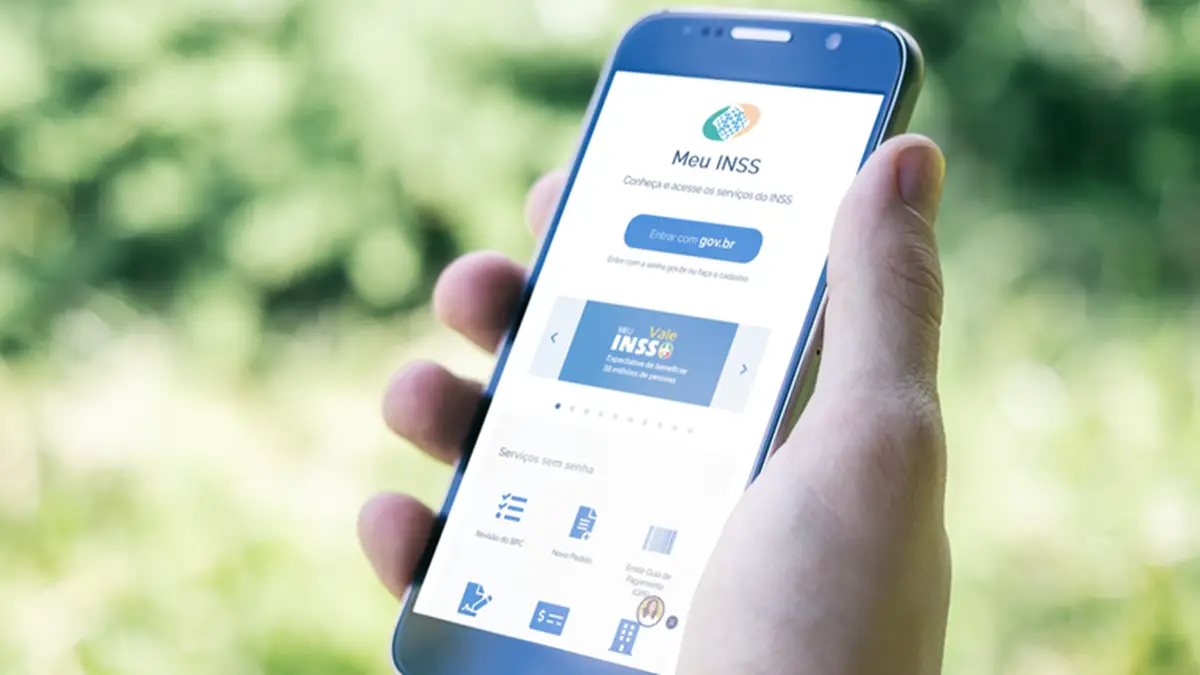 Aplicativo Meu INSS aberto em smartphone mostrando tela inicial com opções de serviços previdenciários