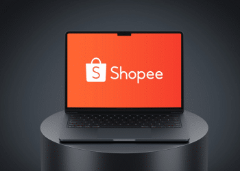 Laptop aberto com tela exibindo o logo branco Shopee sobre fundo laranja