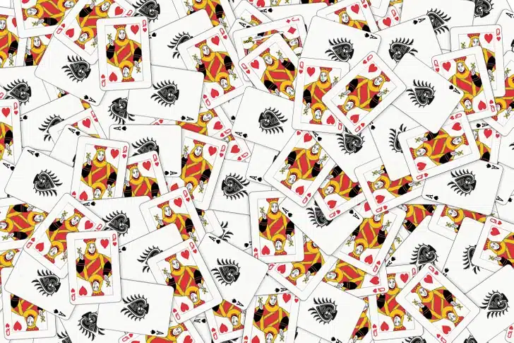 Teste visual com diversas cartas de baralho espalhadas com destaque para damas de copas.