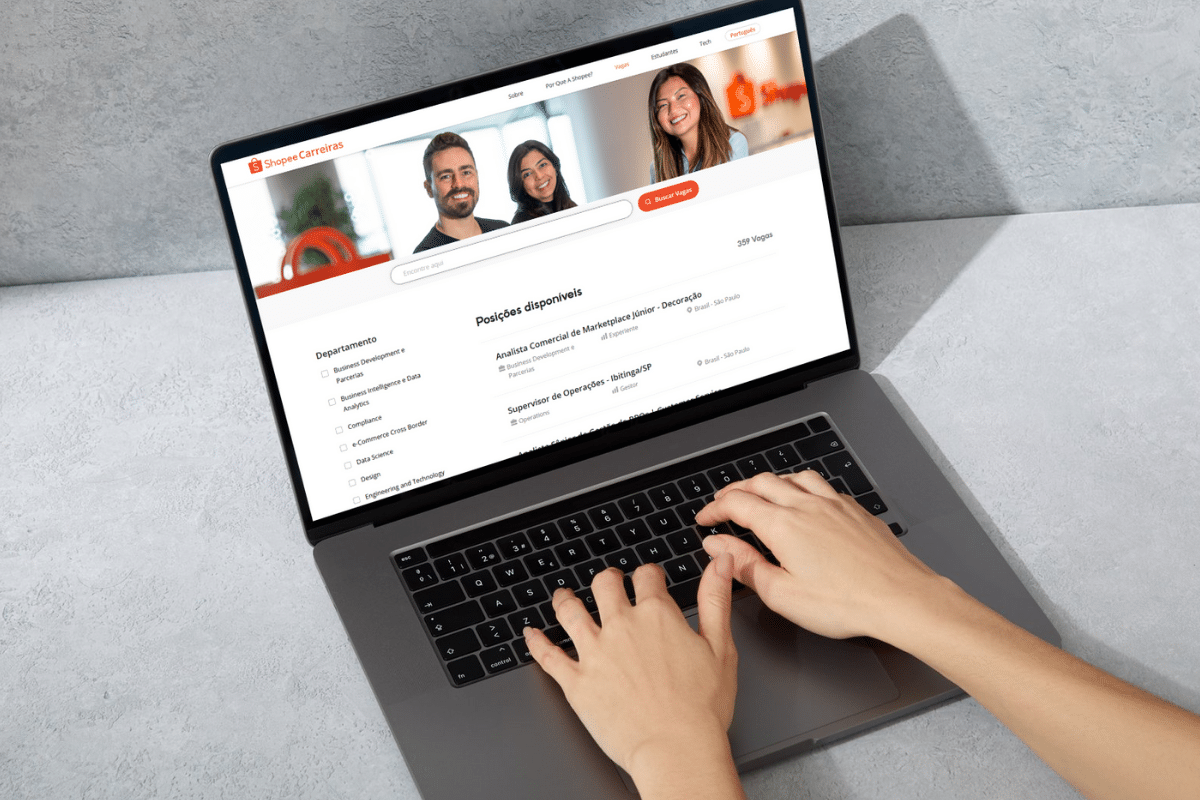 Pessoa navegando na plataforma de carreiras da Shopee em um laptop, exibindo vagas de emprego disponíveis