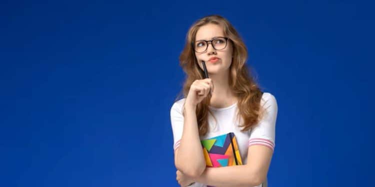 Jovem estudante pensativa, com óculos e caderno, representando a dúvida sobre a forma correta do plural de "mau-caráter".