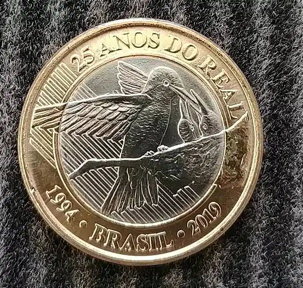 Moeda Rara 1 Real Beija-flor 25 Anos do Real Moeda de 1 Real comemorativa dos 25 Anos do Real (1994-2019), apresentando o desenho do Beija-flor (Amazília Láctea) alimentando seus filhotes. Peça rara e valorizada devido à baixa tiragem.